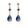 Detail of 18K gold teardrop earring featuring dark blue faceted crystal and floral filigree - Blue