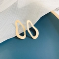 Detailed view of golden irregular geometric hollow oval earrings on white mesh fabric - Streamlined Oval (Silver Earring Post. Minimalist Metal)