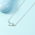 Elegant silver Libra constellation necklace with sparkling zirconia on a blue background - Libra
