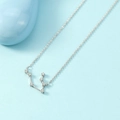 Silver zodiac constellation necklace with sparkling zircons on light blue background - Gemini