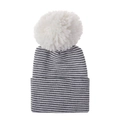 Detailed view of striped knit baby hat featuring a large white faux fur pompom on top - Black And White Striped Hat With White Pom