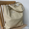 Minimalistische beige Segeltuch-Tragetasche mit Time to Party-Aufnäher auf Holzstuhl - Khaki