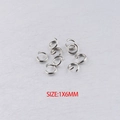 Detailed close-up of silver-colored 1x6mm stainless steel open jump rings on gray surface - Steel