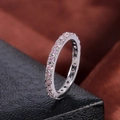 Detailed macro view of eternity ring with pink round-cut stones in micro-pave setting - US 8 / White Gold Plated with Pink Zirconia