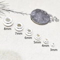 Perle in argento sterling S925 da 3mm a 8mm accanto a una moneta per scala - Argento / 3mm