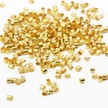 Macro-opname van vergulde koperen knijpkralen voor het maken van sieraden en kettingen - 1.5mm (500 Pieces/Pack) / Goud