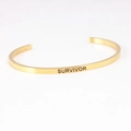 Golden stainless steel C-shaped open bracelet with engraved SURVIVOR text design - SURVIVOR