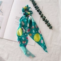 Detailed view of green Christmas scrunchie with long ribbons and festive holiday patterns - Green Christmas Ribbon
