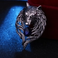 Macro shot of silver wolf head brooch with vintage finish and large deep blue gemstone - Antique Silver