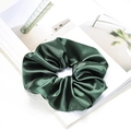 Detailed view of deep green satin silk scrunchie on a clean minimalist magazine page - Dark Green
