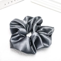 Macro detail of glossy grey satin scrunchie showing smooth texture and soft folds - Smoke