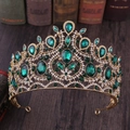 Detailed macro shot of vintage gold crown featuring large green emerald gems and white crystals - KC Gold With Green Rhinestone