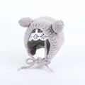 Detalle del tejido de un gorro de invierno para bebé con orejas de oso y cintas - Gris