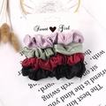 Close-up of four satin hair scrunchies in purple, green, red, and black on a card - Velvet Purple Green Red Black 4-Pack