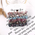 Detail of 6-piece floral fabric scrunchie set displayed on a Sweet Girl card packaging - Floral Pattern 6-Pack