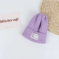 Macro detail of lavender ribbed knit beanie with white woven label on white background - Head Circumference 50-58cm / Purple