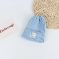 Detailed view of light blue ribbed knit beanie with white textile label on white surface - Head Circumference 50-58cm / Sky Blue