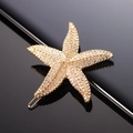 Fermaglio per capelli a forma di stella marina dorata in metallo su base nera lucida - Stella marina d'oro metallizzato