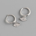 Detailed macro view of S925 sterling silver asymmetrical eye and starburst hoop earrings - White Gold