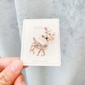 Broche renne en or rose ornée de strass blancs étincelants sur une carte à bijoux - A7-29