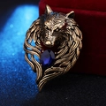 Macro detail of vintage wolf head brooch with bronze finish and a dark blue oval gemstone - Antique Gold