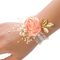 Detailed close-up of pink ribbon rose wrist corsage with pearls and golden leaves - Bright Orange