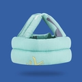 Close-up of mint green baby safety helmet with thick padding and cartoon fabric texture - Blue Elk