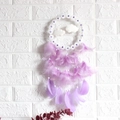 Handmade dreamcatcher with purple flowers and feathers hanging on white brick wall - No Light Version / Purple