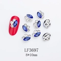 Macro shot of 8x10mm blue marquise nail rhinestones with alloy silver edge on red nails - Silver Base Royal Blue with White (LF3697)