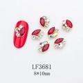 Macro view of 8x10mm red horse-eye nail gem with gold setting and rhinestones - Gold Base Red with Blue AB (LF3681)