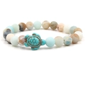 Dettaglio del bracciale con tartaruga marina e perline in pietre naturali opache - Amazonite