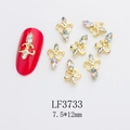 Macro view of 7.5x12mm fleur-de-lis gold nail charm with AB rhinestones on red nail - Gold Fleur-de-lis AB White Rhinestone Style (3733)