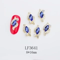 Detailed view of 8x16mm blue navette nail charm with gold base on red manicure - Royal Blue (LF3641)