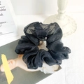 Oversized black organza scrunchie with polka dot pattern on a fashion magazine - Black