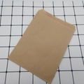 Single brown kraft paper bag with serrated top edge on minimalist grid background - Original Kraft Color