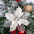 Macro detail of glittering white Christmas flower decoration on a snowy pine branch - White