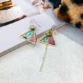 Detail of asymmetric ethnic earrings with gold floral frame and elegant long tassel - Asymmetric Triangle