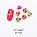 Macro detail of 8x10mm alloy nail art charms with red marquise crystals and gold edging - Gold Base Dark Red with Purple (LF3670)