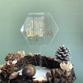 Detail of a transparent hexagonal acrylic Merry Christmas cake topper with gold foil lettering - Gold Foil Hexagon
