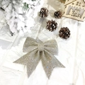 Gros plan d'un nœud de Noël doré pailleté sur un fond blanc festif avec des décorations - Champagne
