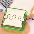 Close-up of a green crown-shaped plastic sandwich cutter on a wooden board - Crown - Green