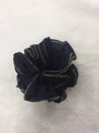Dark blue fabric scrunchie with elegant golden trim on soft white plush background - Blue