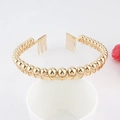 Elegant gold metal headband featuring round beads and secure side combs on white base - Beads-Gold