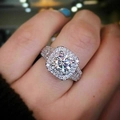 Close-up of double halo pavé ring with brilliant center stone on a hand model - US 8 / White