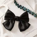 Macro shot of large black satin bow hair clip on a minimalist artistic display background - Spring Clips / Black