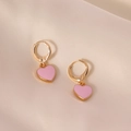 Chique roze hart oorbellen met gouden metalen frames op zachte zijden achtergrond - Roze
