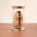 Detail of nude gourd makeup puff in clear case with metallic base and lid - Gourd Shape (Cylinder Pack) / Milk Tea