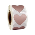 Detail view of heart-shaped rose gold scratch-off sticker labels on a roll for packaging - Small Roll / Rose Gold
