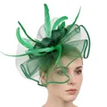 Dettaglio dell'acconciatura verde smeraldo con velina a rete e piume decorative - Verde