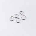 Five polished silver stainless steel open jump rings on a textured gray background - 1.2*10mm / Steel